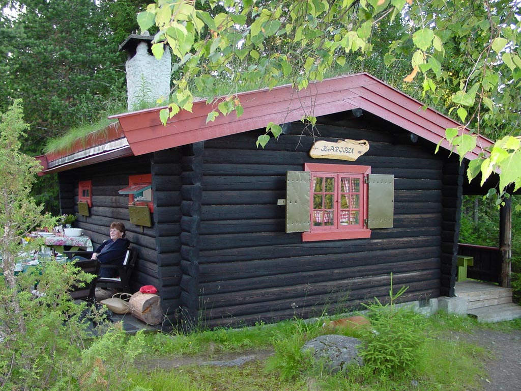 Karibu-hytta omgitt av skog